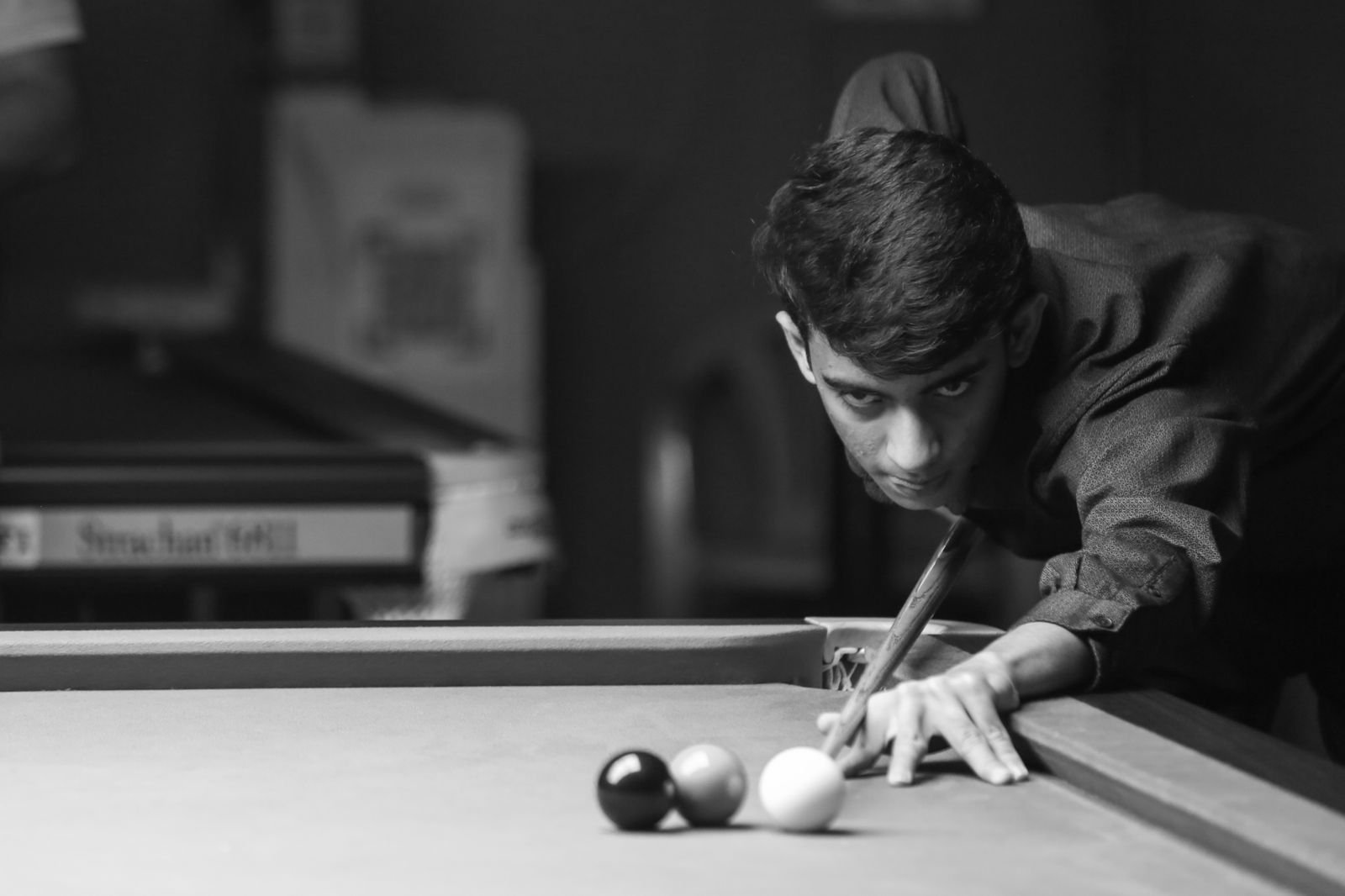 Black-and-white photograph of Rahul Williams in a snooker stance