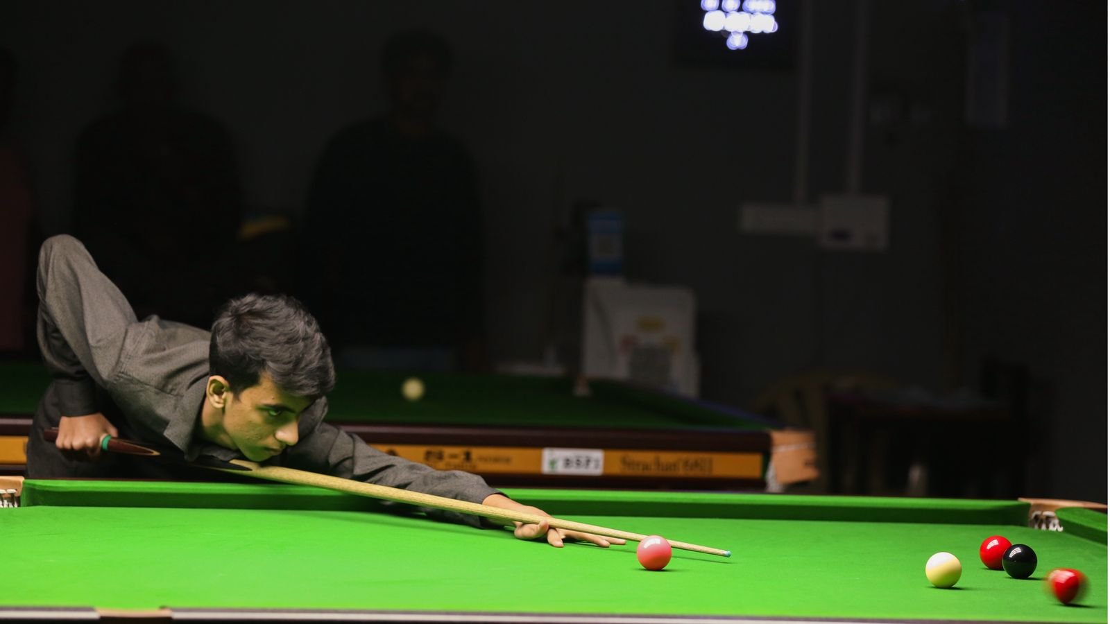 Rahul Williams lining up a snooker shot, cue down on the table