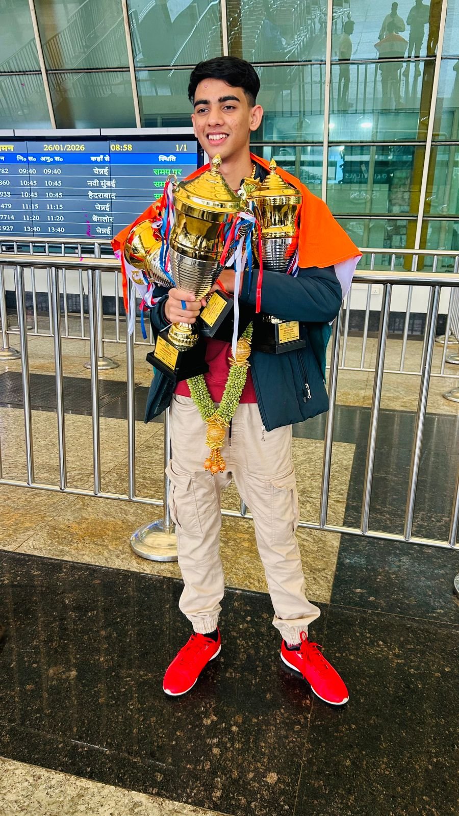 Rahul Williams holding trophies with the Indian flag after international competition