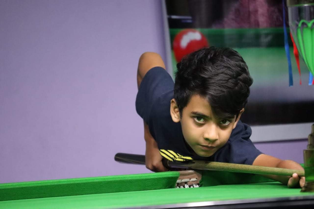 Young Rahul Williams playing snooker at the table